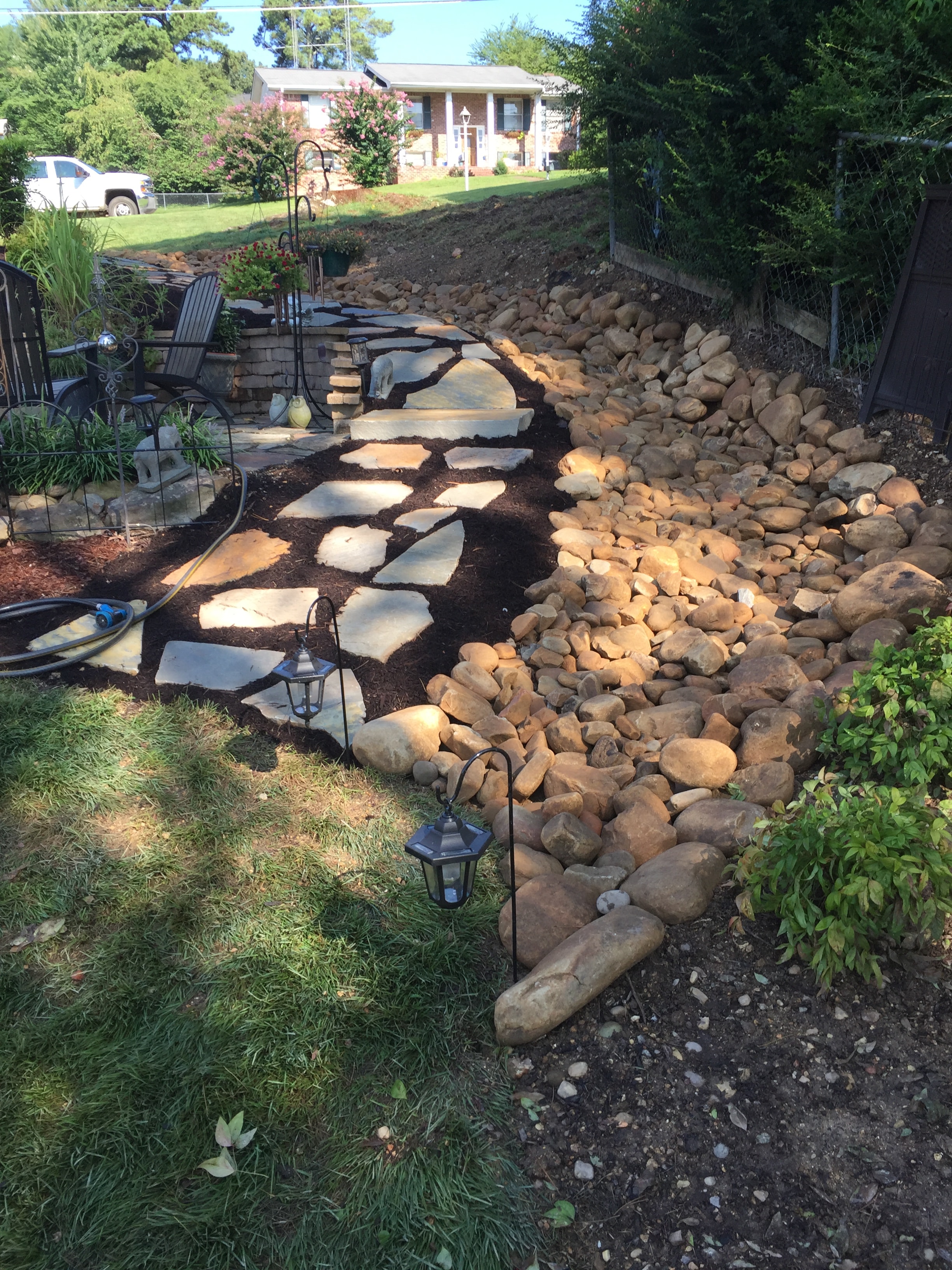 Natural stone patio with boulder border and garden lanterns