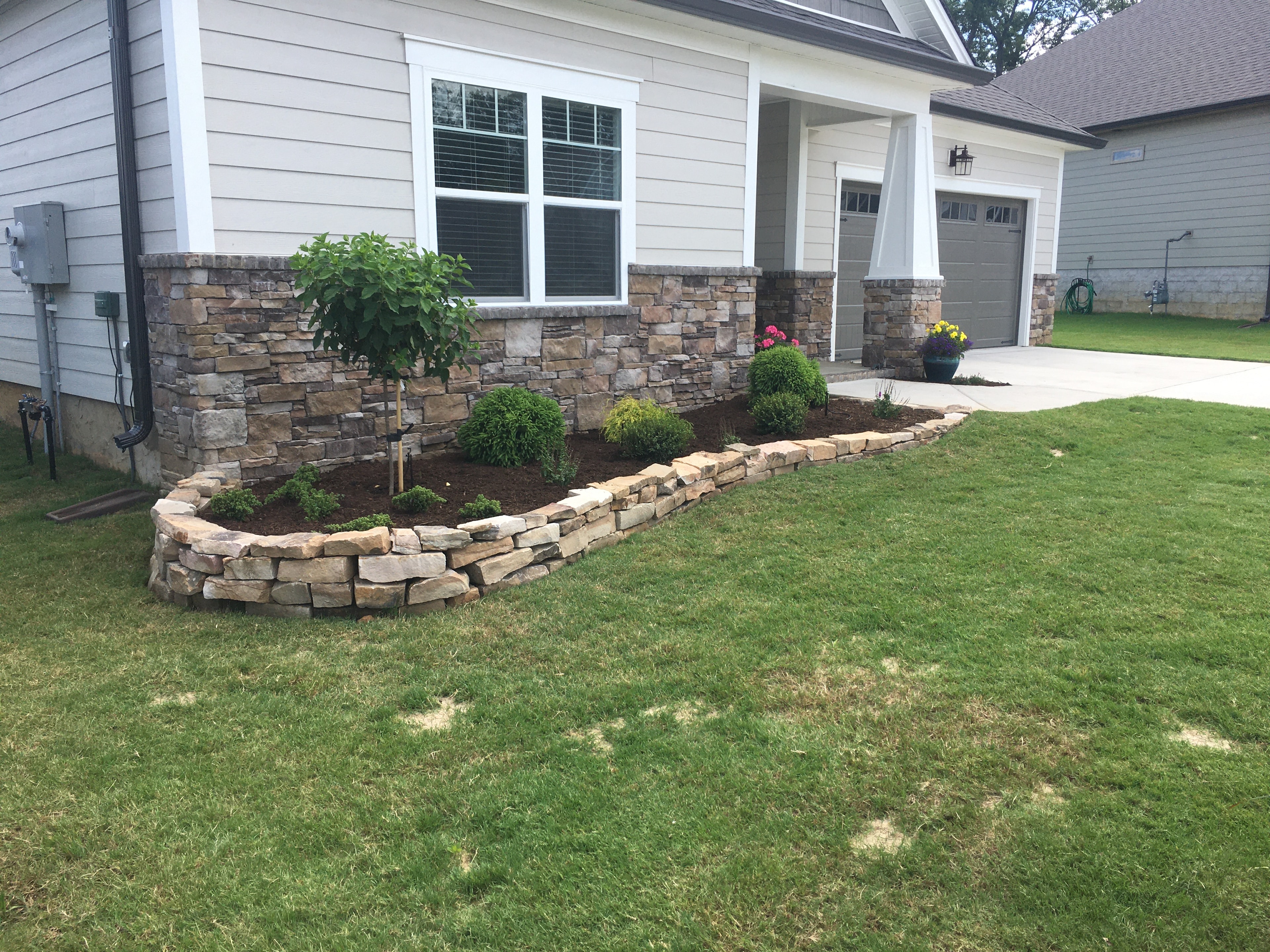 Stone veneer retaining wall with hanging planters